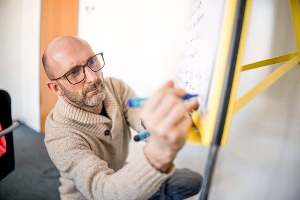 Ein CONTRACT-Berater macht in einem Workshop zu Prozessoptimierung Notizen auf dem Flipchart