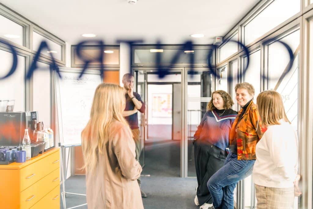 Mitarbeiter:innen von CONTRACT unterhalten sich auf dem Flur