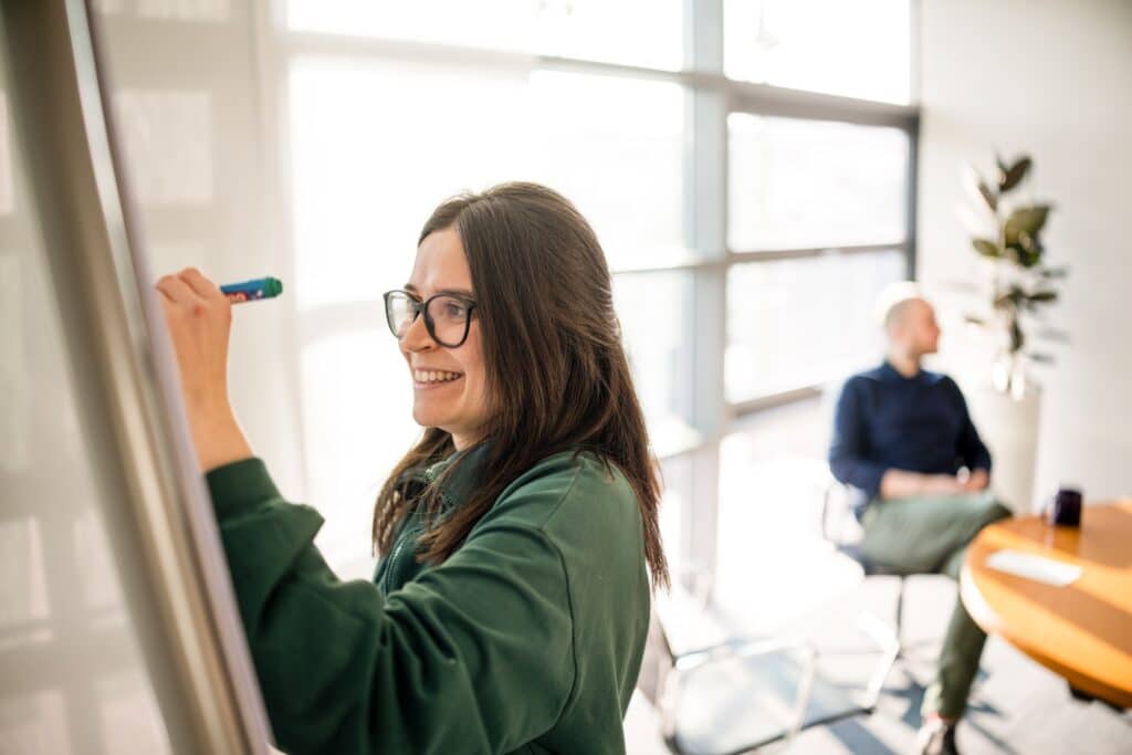 Eine CONTRACT-Beraterin schreibt im Rahmen eines Workshops zur Personalentwicklung auf ein Flipchart