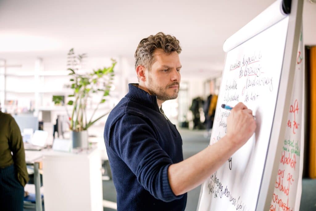 Ein CONTRACT-Berater erarbeitet am Flipchart, wie sich Transformation im Unternehmen aktiv steuern lässt